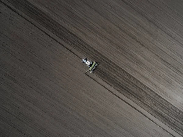 Parlak mavi traktör kara toprağı çerçevede bir yere sürme. Üstten görünüm