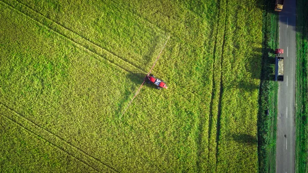 Lantbruksmaskiner i fältet. Traktor med en spruta. Flygfoto — Stockfoto