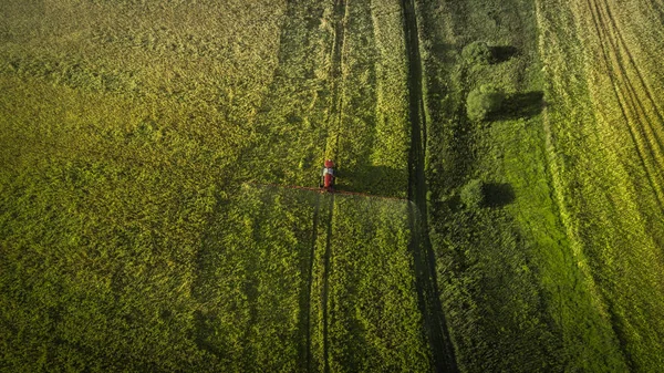 Lantbruksmaskiner i fältet. Traktor med en spruta. Flygfoto — Stockfoto