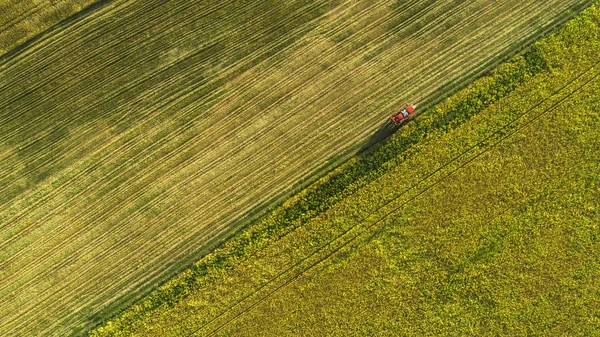 Landbouw-machines in het veld. Trekker met een sproeier. Luchtfoto — Stockfoto