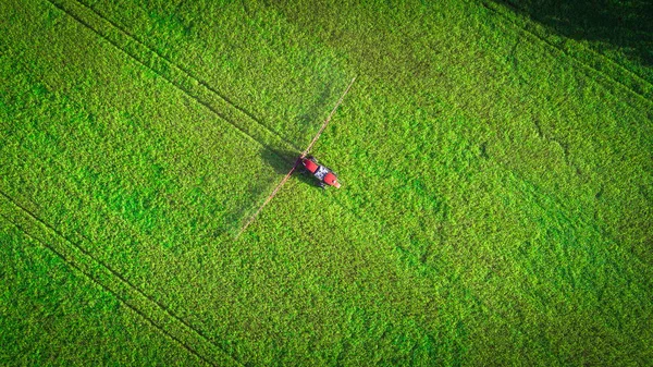 Maquinaria agrícola en el campo. Tractor con pulverizador. Vista aérea — Foto de Stock