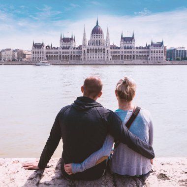 İki kişi Rıhtımlar üzerinde oturmak ve Budapeşte, Meclis'te manzarasının keyfini çıkarın