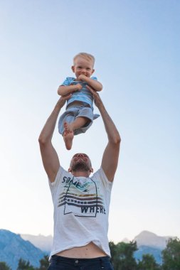 Baba ve oğul sahilde günbatımı anda oynamak.