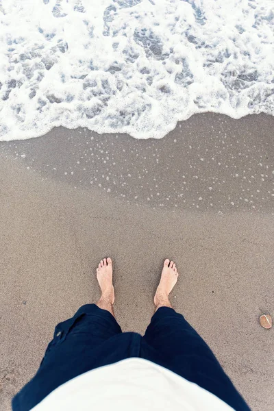 Olas azules en la arena con los pies masculinos —  Fotos de Stock
