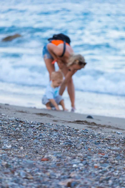 Mor och son promenader på solnedgången stranden — Stockfoto