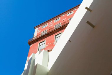 Kentsel geometri, yukarıya bakıyor. Modern beyaz renkte bina ve eski parlak pembe renkte bina