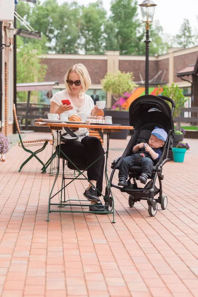 Giovane madre con il suo bambino di un anno in un caffè di strada — Foto Stock