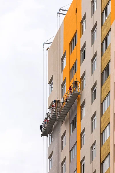 Les constructeurs peignent la façade d'un immeuble résidentiel de grande hauteur — Photo