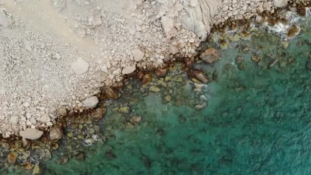 Vista aérea de una costa de acantilados con piedras y olas de mar turquesa. Vídeo vertical aéreo 4K — Vídeos de Stock