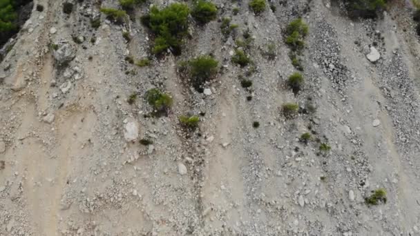 Vue aérienne d'une falaise côtière avec des pierres et des vagues de mer turquoise. Vidéo aérienne verticale 4K 