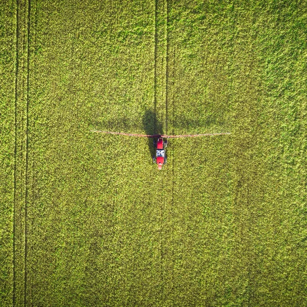 Agricultural machinery in the field. Tractor with a sprayer. Aerial view