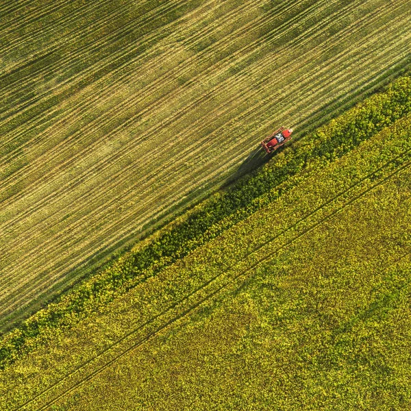 Macchine agricole sul campo. Trattore con spruzzatore. Vista aerea — Foto Stock