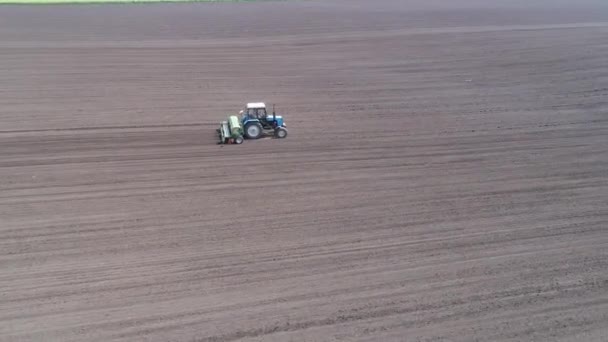 Rundflug-Luftaufnahme von zwei Traktoren, die nacheinander über das Feld fahren — Stockvideo