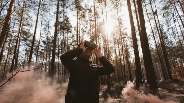 妇女在森林与虚拟现实耳机看起来与橙色烟从烟雾炸弹 — 图库照片