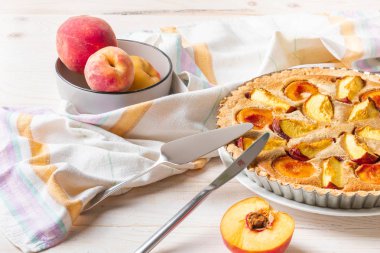 Beyaz ahşap arka planda ev yapımı Açık Şeftali pasta.
