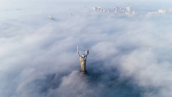 Nubi spesse di nebbia autunnale e il monumento della Patria che ne fuoriesce — Foto Stock
