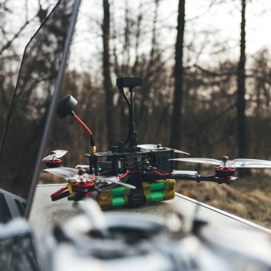 FPV drone laptop ve kontrol panelinin yakınında masada yatıyor.