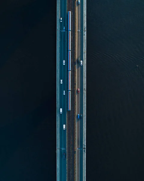 Bridge with two lanes and subway or train rails on a background of dark water. Aerial view — Stock Photo, Image