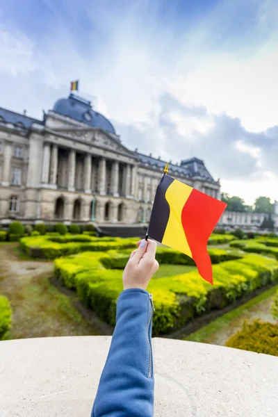 Palazzo Reale di Bruxelles e bandiera del Belgio in mano femminile, Belgio — Foto Stock