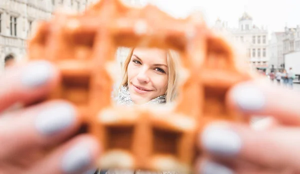 在比利时布鲁塞尔大广场的背景下拿着华夫饼的妇女 — 图库照片