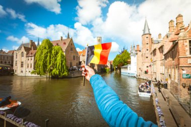 Flag of Belgium against the background of attractions in Bruges, Belgium clipart