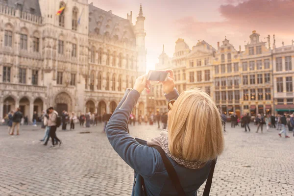 Žena stojí na náměstí Grand Place v Bruselu, v Belgii při západu slunce. Fotografie sociálních sítí — Stock fotografie