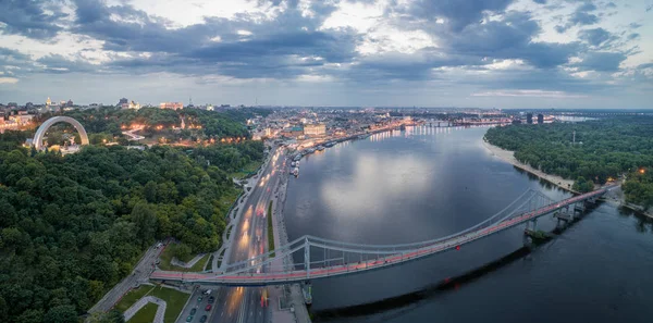 Vista aérea nocturna de la ciudad de Kiev cerca del puente peatonal . — Foto de Stock