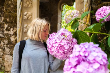 Eski parkta pembe ortancalar ile sevimli kız.