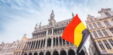 Kadın turist elinde Brüksel Grand-Place Meydanı arka planda Belçika bayrağı tutar, Belçika