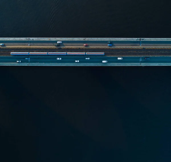 Bridge with two lanes and subway or train rails on a background of dark water. Aerial view — Stock Photo, Image
