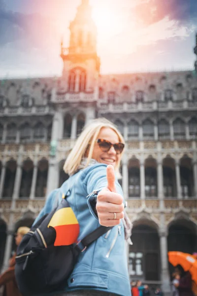 Una viajera se para en la Grand Place Square de Bruselas y muestra sus pulgares hacia arriba, Bélgica . — Foto de Stock