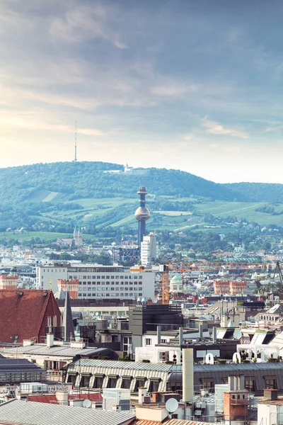 Panoramiczny widok na miasto o zachodzie słońca z fragmentem rury spalarnika Spittelau na horyzoncie. — Zdjęcie stockowe