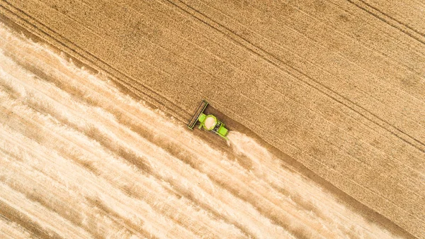 Colheitadeira trabalhando no campo e corta trigo. Ucrânia. Vista aérea . — Fotografia de Stock
