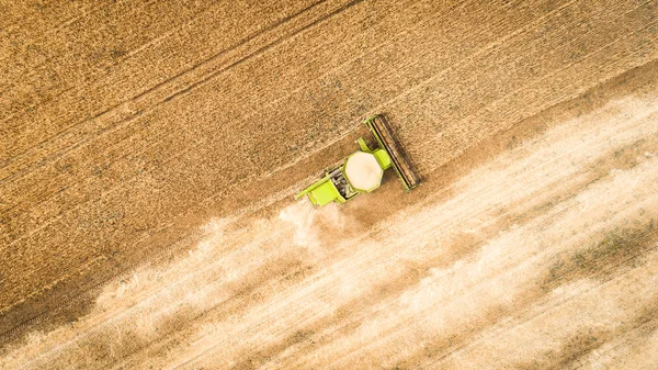 Colheitadeira trabalhando no campo e corta trigo. Ucrânia. Vista aérea . — Fotografia de Stock