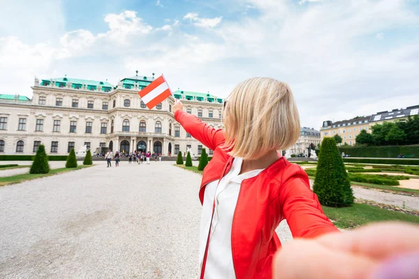 Samičí cestovatel s rakouskou vlajkou na pozadí horního Belvederského paláce ve Vídni. — Stock fotografie