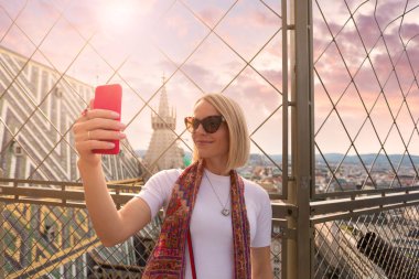 Avusturya'nın Başkenti Viyana'daki St. Stephens Katedrali'nin çatısında bir kadın telefonunda selfie fotoğrafı çekiyor.