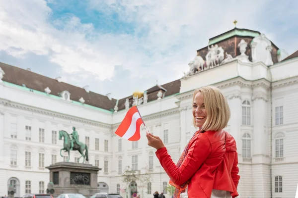 Una joven con la bandera de Austria en el fondo de la Biblioteca Nacional de Austria en Viena . — Foto de Stock