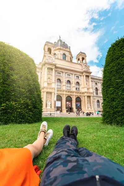 Um casal jaz na grama contra o pano de fundo do Museu de História Natural em Viena, Áustria — Fotografia de Stock