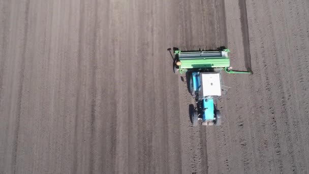 Вид с воздуха на тракторы, движущиеся по полю — стоковое видео