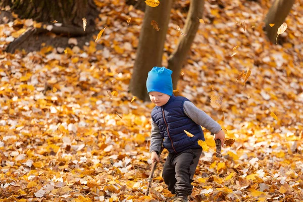 Dítě si hraje v podzimním listí — Stock fotografie