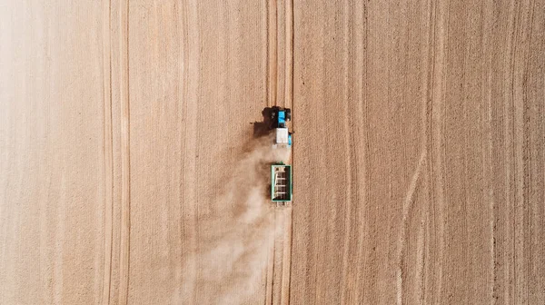 비료와 씨를 뿌려 밭에서 일하는 푸른색 트랙터 를 공중에서 본 모습 — 스톡 사진