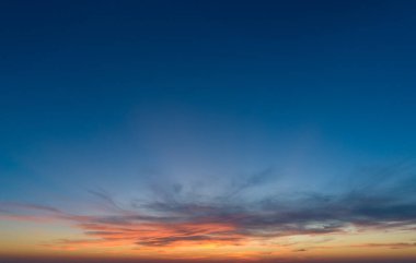 Günbatımı gökyüzü ve çok renkli bulutlu büyük bir manzara.