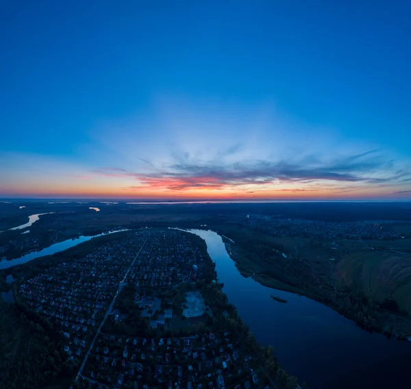 Veduta aerea panoramica del paesaggio naturale con prati verdi e un fiume al tramonto. — Foto Stock
