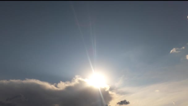 Un metraje del cielo diurno con el sol en el medio y nubes volando y una gran nube. — Vídeos de Stock