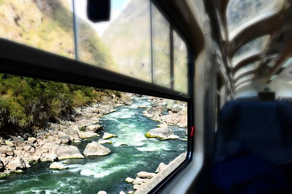 Train window view of a river. Mountain river in Peru.