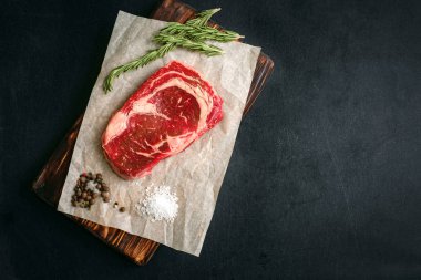 siyah arka plan, üstten görünüm ahşap bir gemide ham antrikot biftek