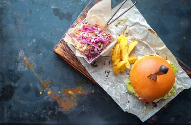 çizburger paslı çelik arka plan üzerinde pişirme eve kapatmak patates kızartması ve salata üstten görünüm