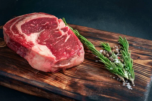 Bife Ribeye Cru Deitado Uma Placa Madeira Com Churrasco Temperado — Fotografia de Stock