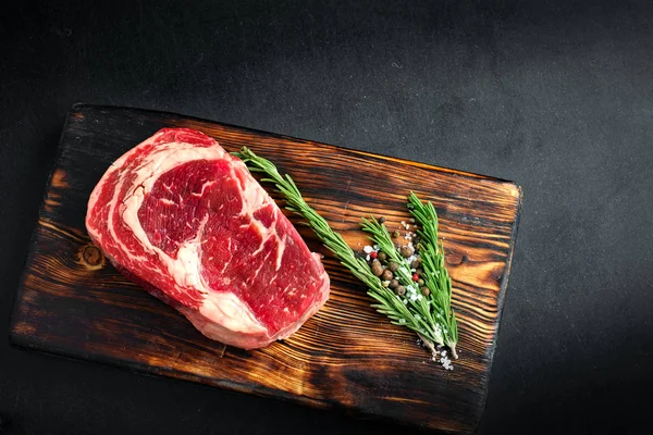 Rohe Ribeye Steak Auf Einem Holzbrett Liegend Mit Gebackenen Gewürzten — Stockfoto