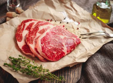 çiğ dana kaburga taze et eti biberiye, karabiber ve zeytinyağı, yukarıdan görünüm, yakın çekim ile beyaz kağıt üzerinde